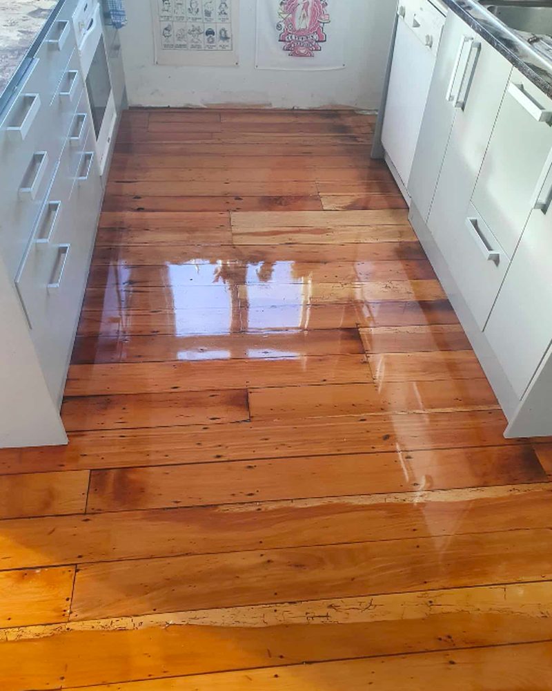 The same kitchen after timber floor sanding and polishing, warm glossy honey boards
